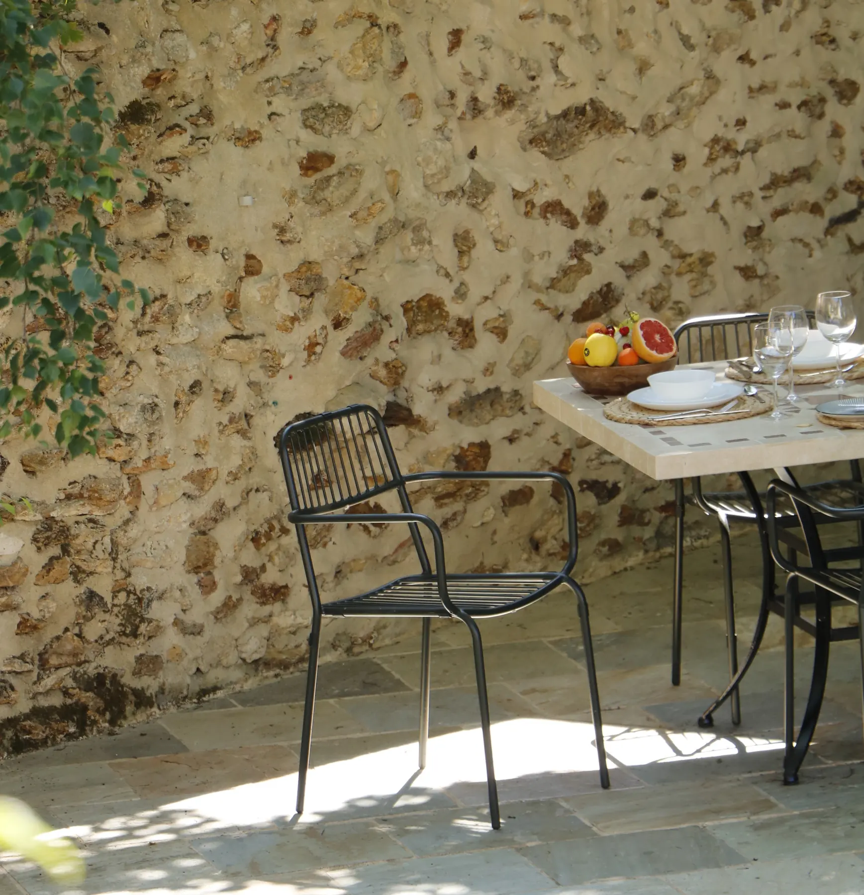Table de bistrot dans la cour en pierre de la Maison Auguste
