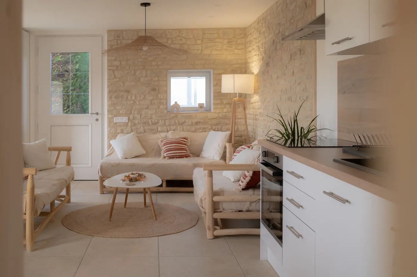 Séjour lumineux au mur de pierres de la Maison Raphaël